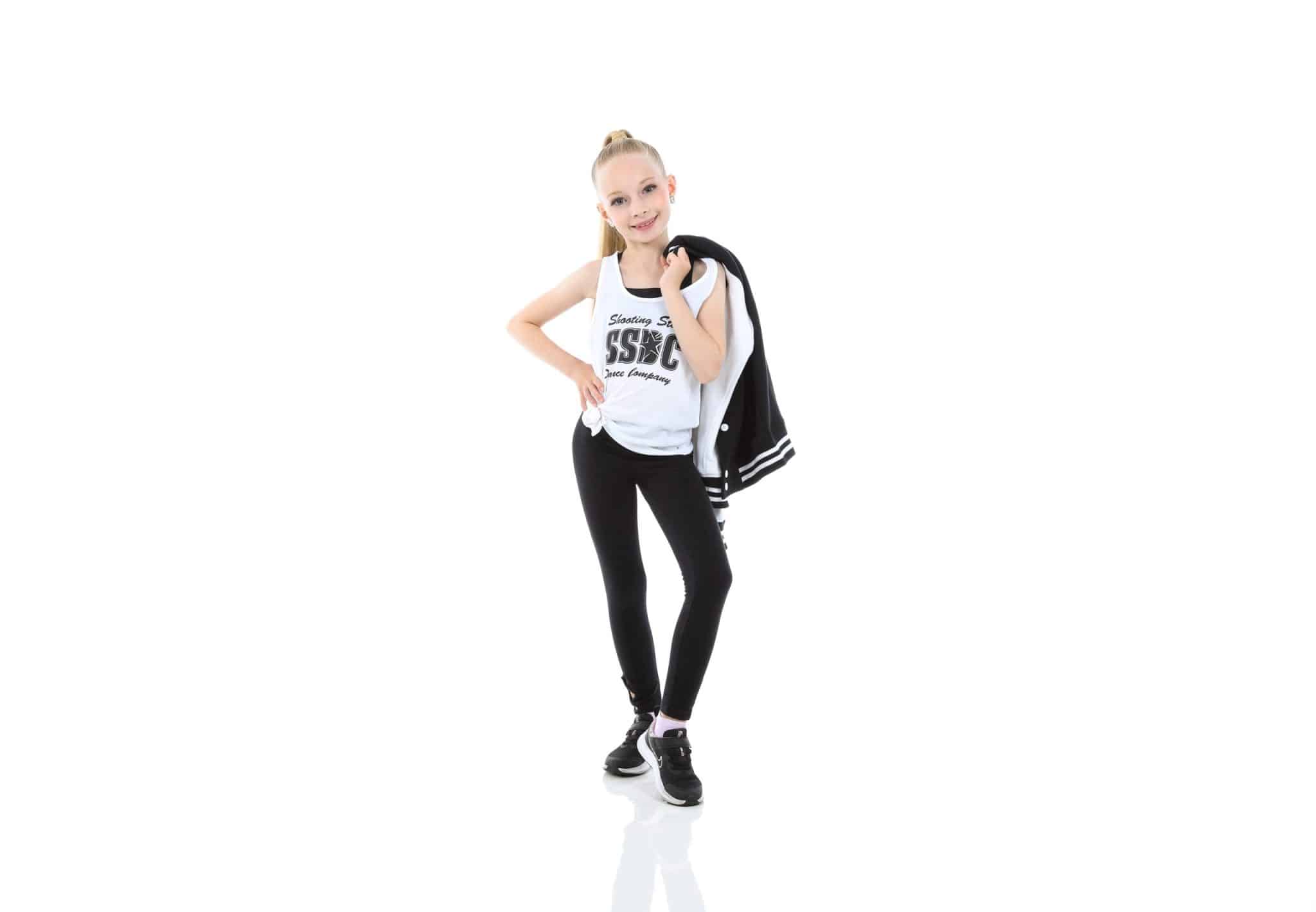 Shooting_Stars dancer posing in Shooting_Stars Dance Company gear with jacket over shoulder and confident smile