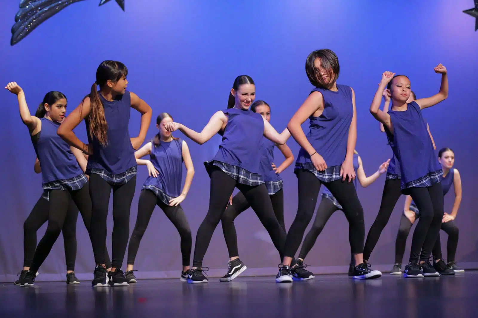 Empire Dance Center’s teen hip hop group dancing in blue and black outfits.