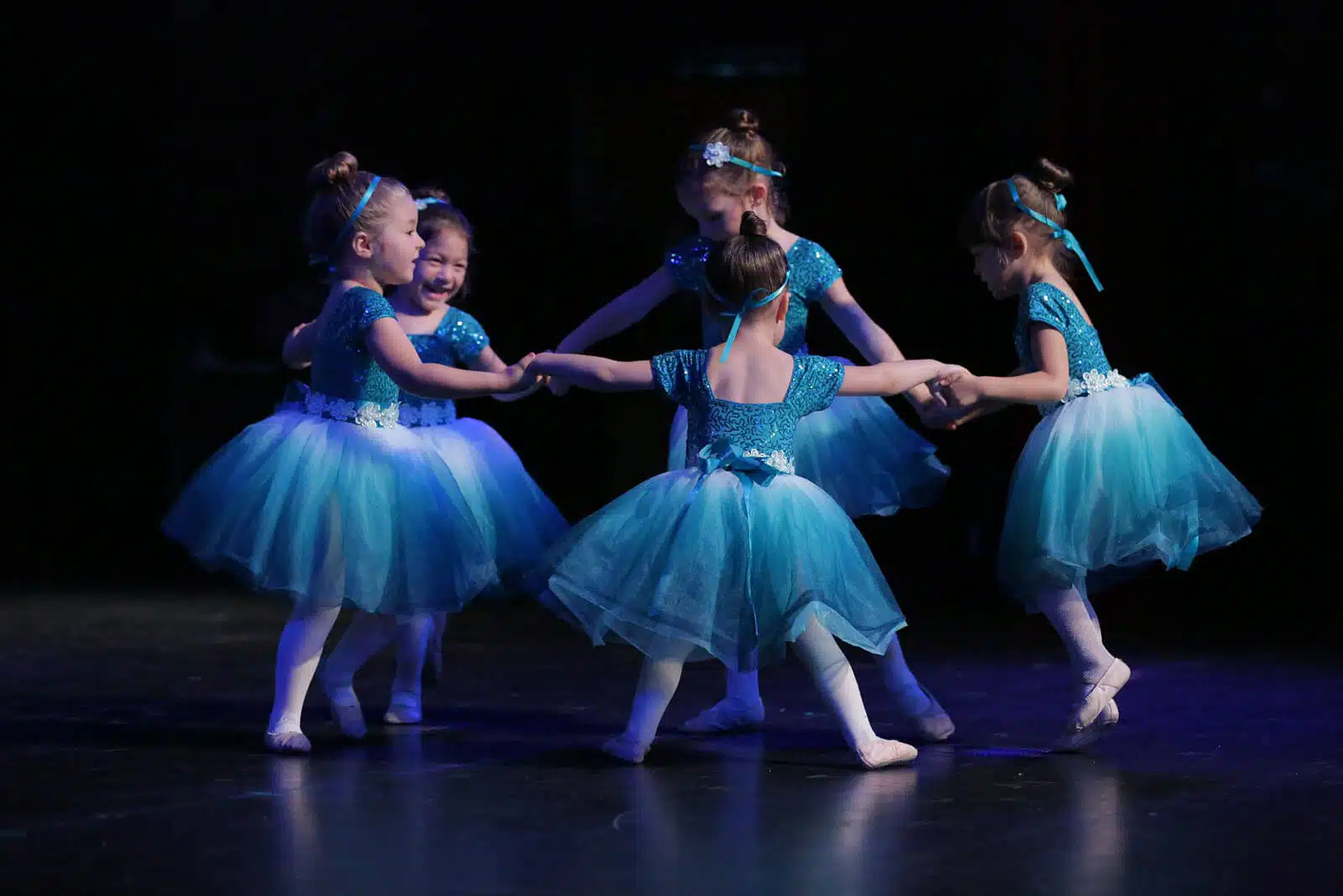 Three young Empire Dance Center ballerinas performing in blue tutus.