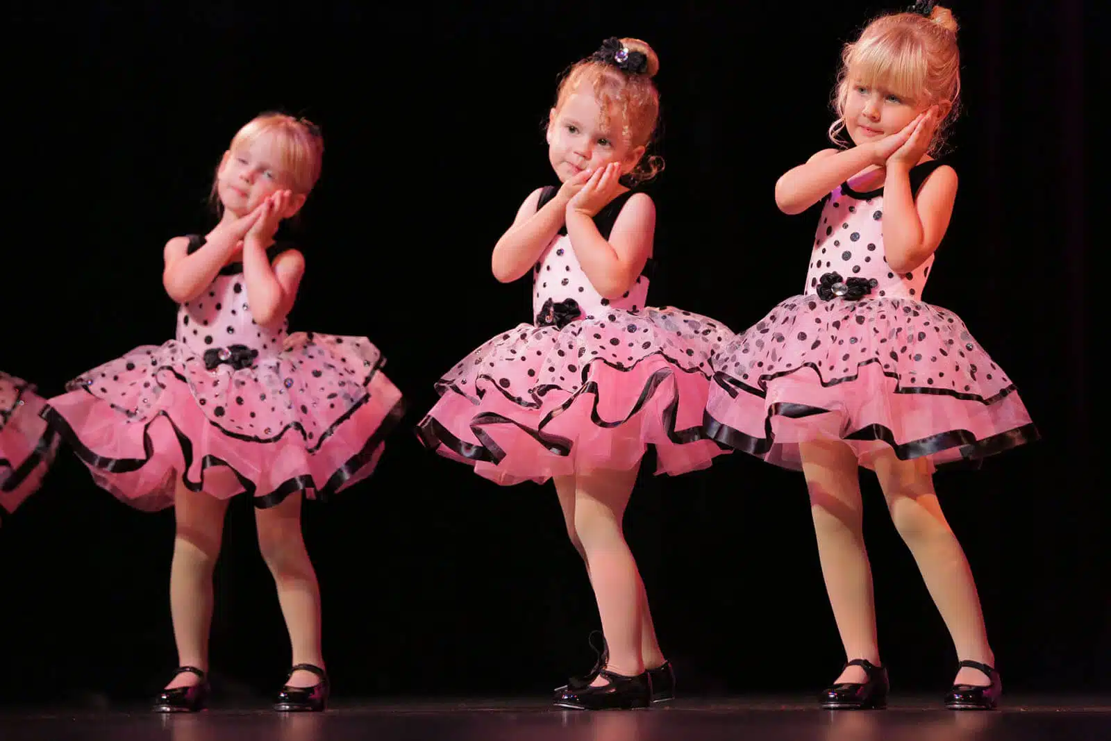 Young girls from Empire Dance Center smiling in pink polka-dot dance costumes.